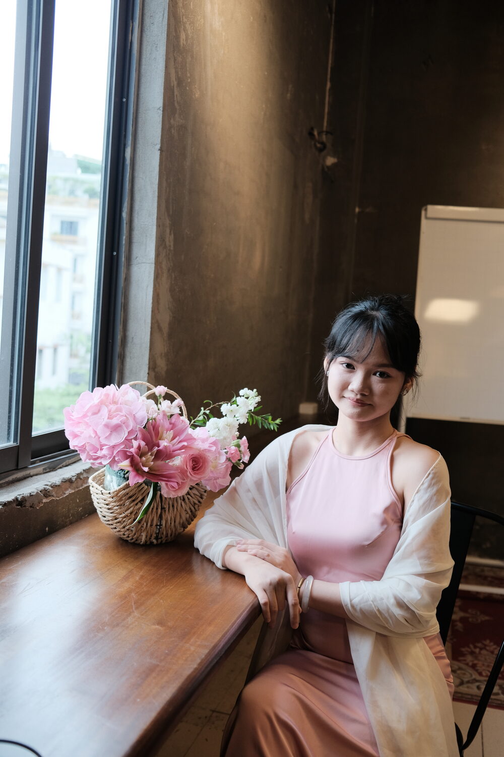 Ảnh chụp tặng học viên bên cửa sổ với giỏ cẩm tú cầu